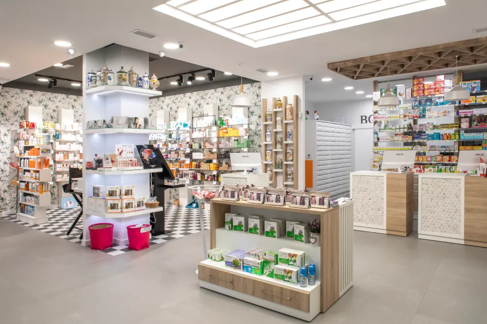 Zona de atención al cliente en la farmacia La Botica reformada, con mostradores bien definidos, iluminación cálida y diseño funcional para una atención eficiente