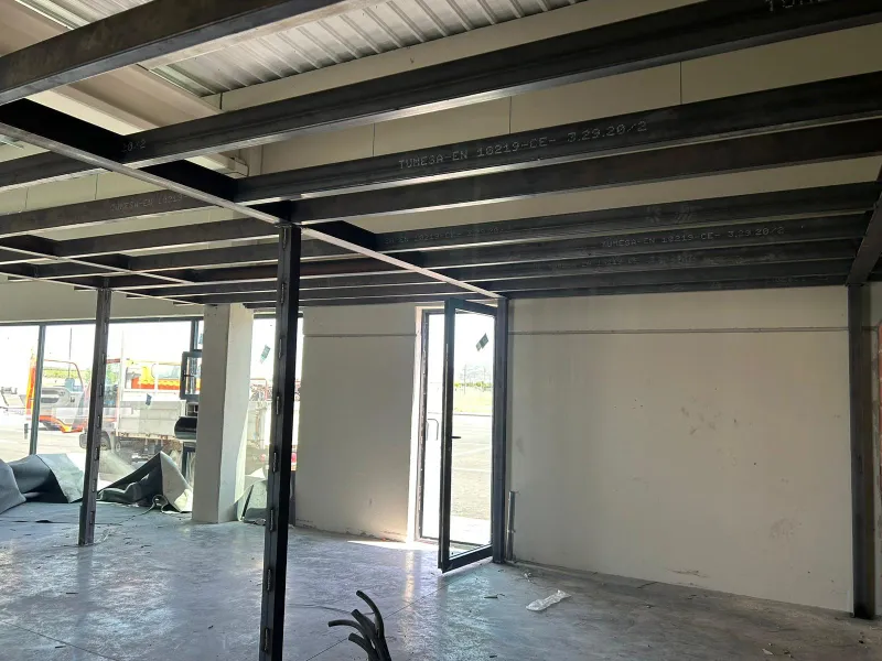 Imagen del interior vacío de la nave industrial con estructura visible antes de la reforma interior de LANAVE Farmacia